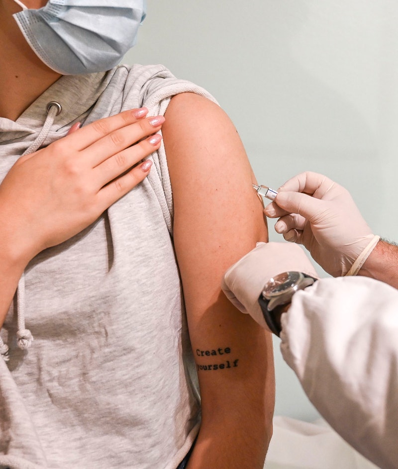 A woman wearing a mask gets a coronavirus vaccine. Experts explain how much a covid vaccine should c...