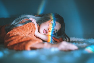 Woman Lying Down On Bed With Rainbow On Face