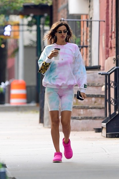 Irina Shayk wearing a tie-dye matching sweater and shorts in white-pink-green, and pink Ugg boots
