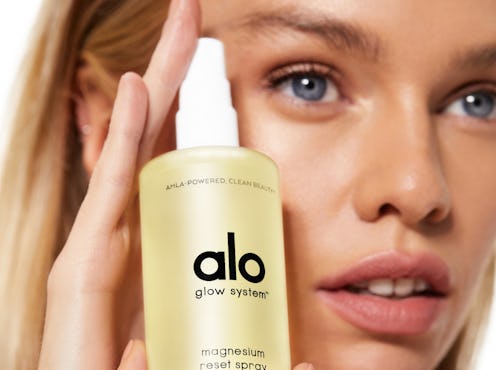 Model holding the facial spray from Alo Yoga's new beauty line.