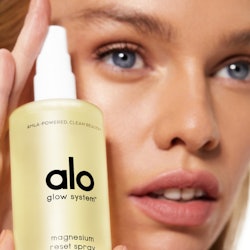 Model holding the facial spray from Alo Yoga's new beauty line.
