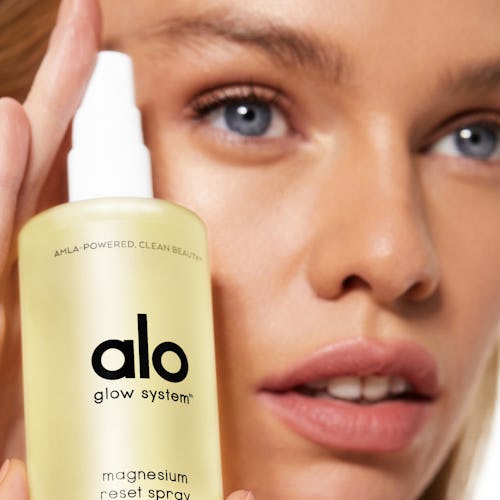 Model holding the facial spray from Alo Yoga's new beauty line.