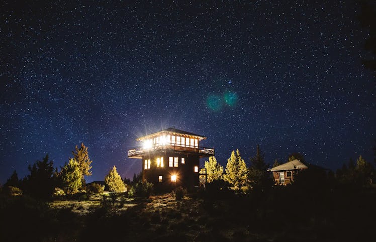 A tower listed on Airbnb sits in the woods with great views at night. 