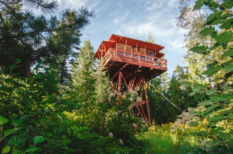 The Crustal Springs Lookout tower on Airbnb is red and sits above the trees in Idaho. 