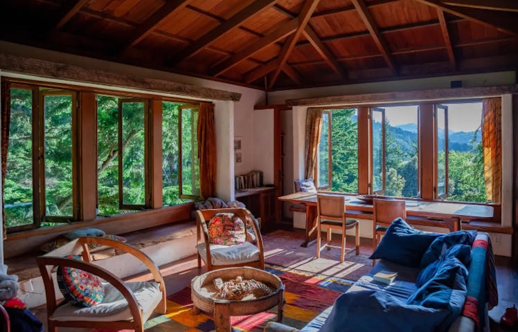 The Lost Coast Tower listed on Airbnb has a colorful living room with windows all around, overlookin...