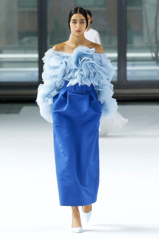 A model wearing a ruffled light blue top and a blue belted skirt from Carolina Herrera Fall/Winter 2...