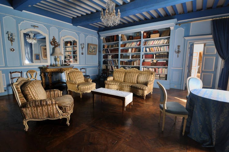 An elegant blue room in an Airbnb castle has books on the shelves, just like the library in 'Beauty ...