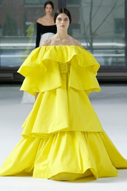A model walking the runway in four-tier belted gown in acacia yellow from Carolina Herrera Fall/Wint...