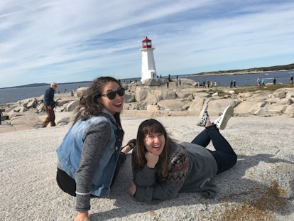 Friends lounge on rocks and pose by a lighthouse in one of the ports of call on a Disney Cruise. 