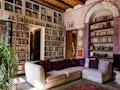 Books fill the bookshelves on the walls of this bright living room that's listed on Airbnb. 