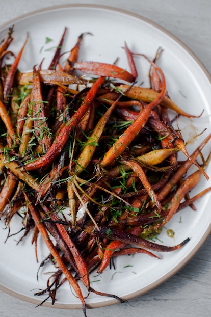 A plate of roasted carrots garnished with fresh-cut herbs