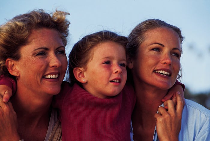 Three generations of females hug in an archival photo from the 1980s
