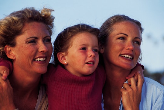 Three generations of females hug in an archival photo from the 1980s