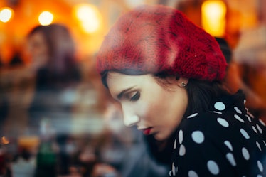 Young woman with red hat in window