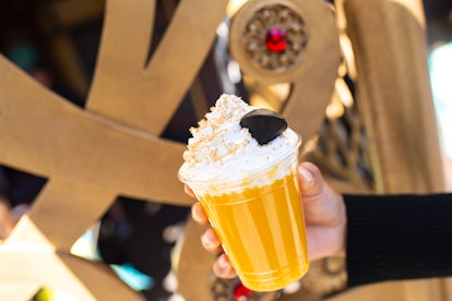 A woman holds up a yellow slush drink inspired by Jafar from 'Aladdin' for the Disney Villains After...