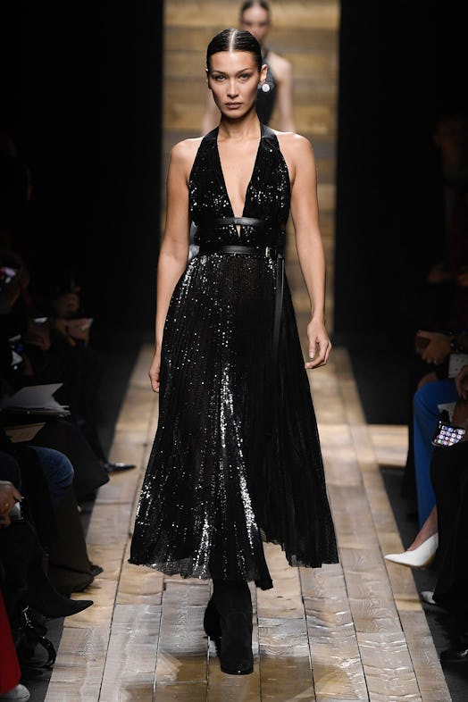 Bella Hadid wears a glittery black dress with an open neckline from Michael Kors Fall 2020 Collectio...