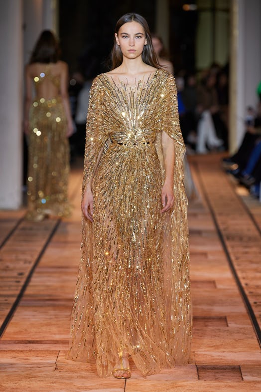 A female model walking in a Zuhair Murad feather-trimmed gown