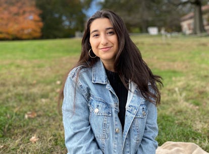 A Latinx writer Natasha Miñoso sitting outside.