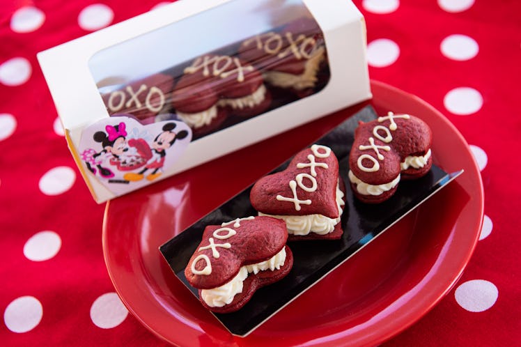 Three red velvet whoopie pies with "XOXO" written on them sit on a red plate for Valentine's Day at ...