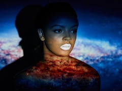 Young black woman in front of galaxy, universe background