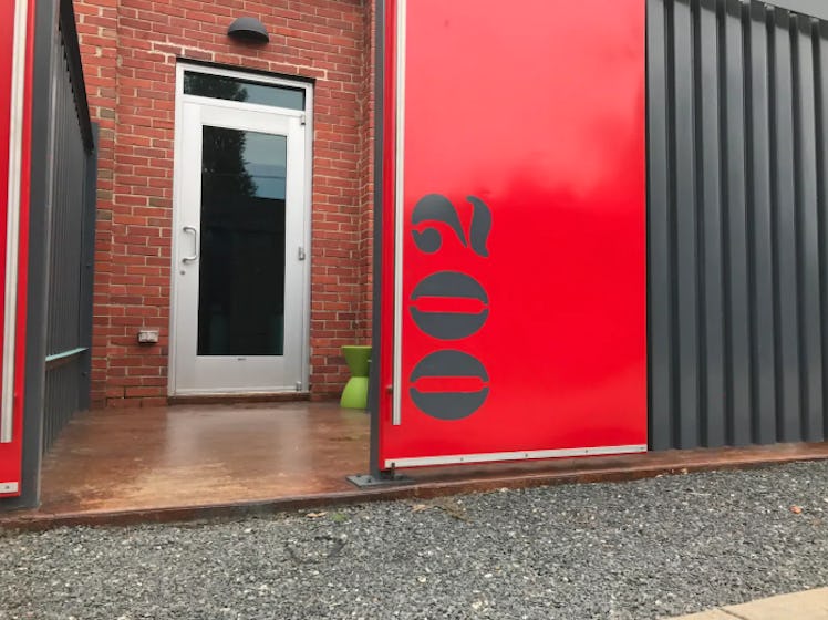 The front door to an apartment in a renovated airplane hangar that's listed on Airbnb is painted red...