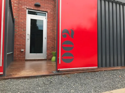 The front door to an apartment in a renovated airplane hangar that's listed on Airbnb is painted red...