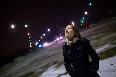 Young woman looking up at moon, night sky