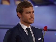 Pilot Pete from 'The Bachelor' holds a rose to hand out in front of an airplane.