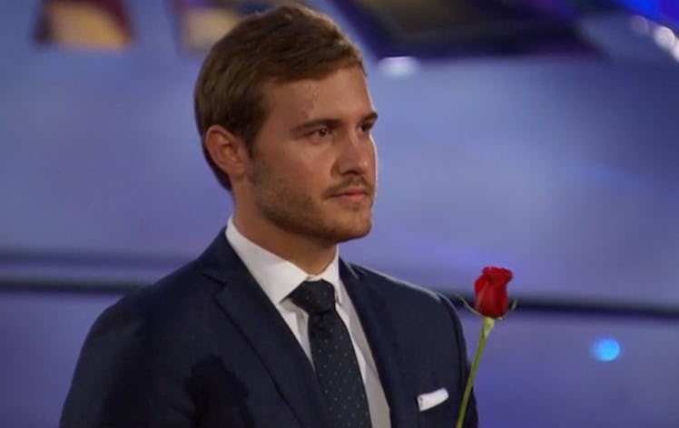 Pilot Pete from 'The Bachelor' holds a rose to hand out in front of an airplane.