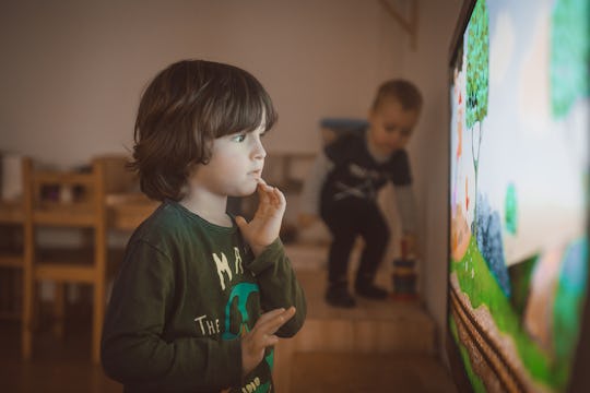 Child stands very close to television