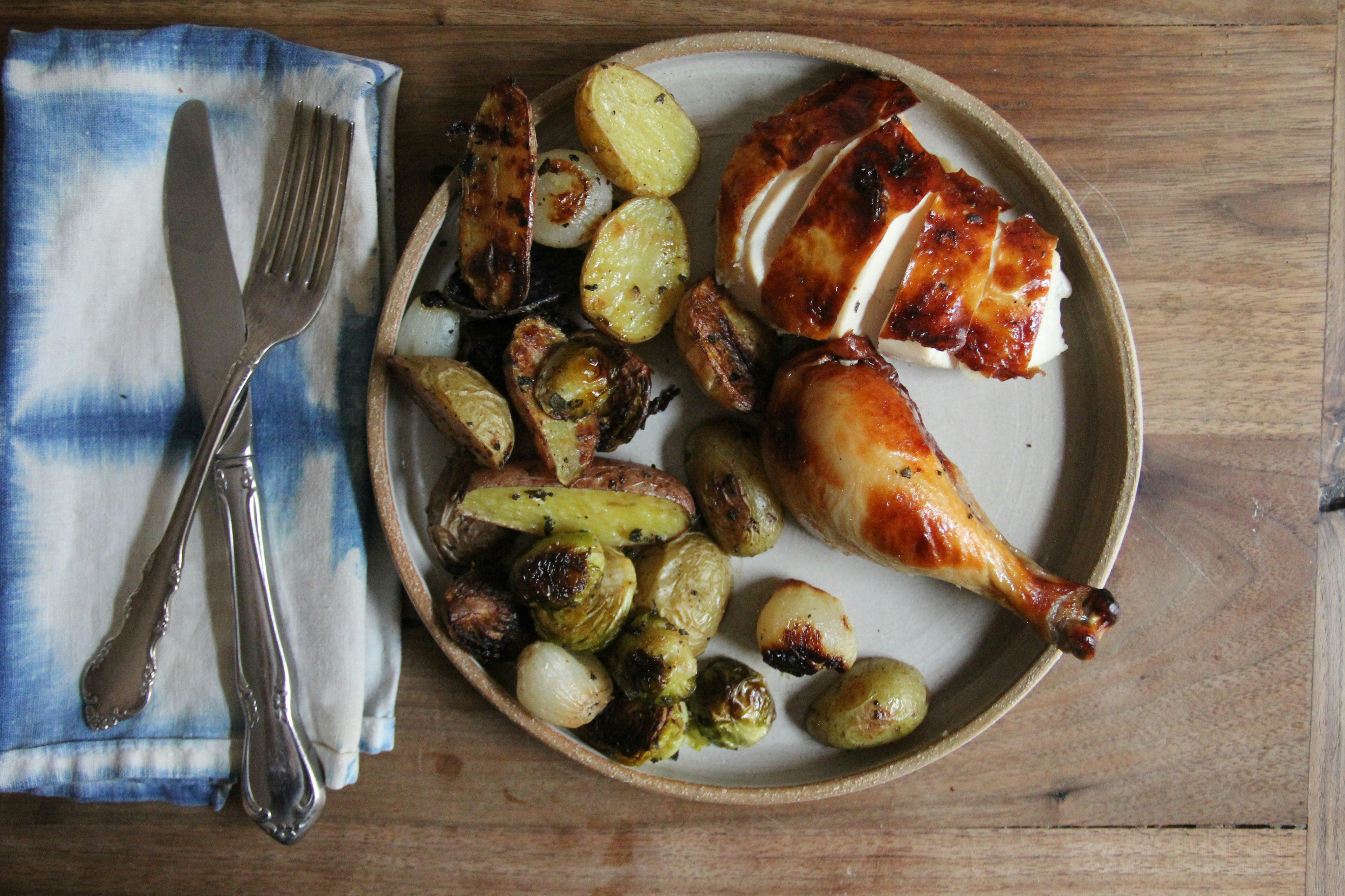 Cooked chicken served on a plate with potatoes 