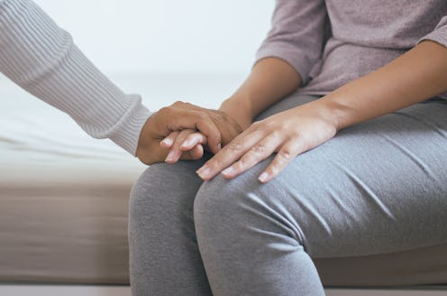 A woman holds an eating disorder patient's hand. OSFED, or eating disorders that fall outside the cl...