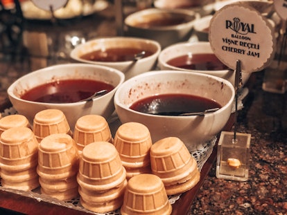 Ice cream cones fill a tray on a counter next to bowls of cherry jam in Cappadocia, Turkey.