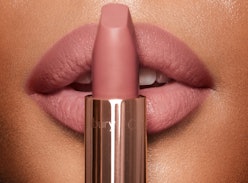 A woman holding Charlotte Tilbury Pillow Talk best-selling lipstick in front of her lips
