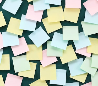 Blue, yellow, and pink sticky notes on a green wall