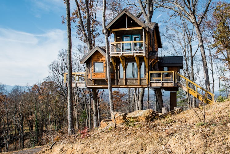 A two-story treehouse in North Carolina is surrounded by trees and available to rent on Airbnb. 