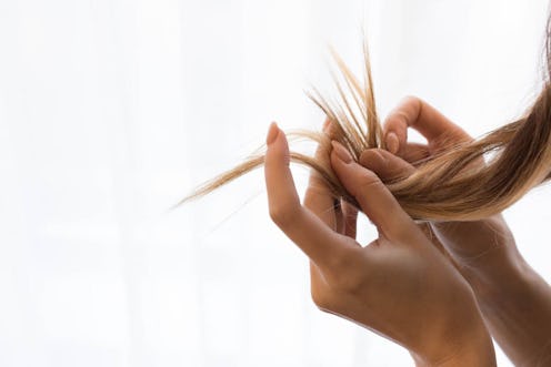 A woman's hands examine her split ends. Words for sadness and depression that aren't translatable in...