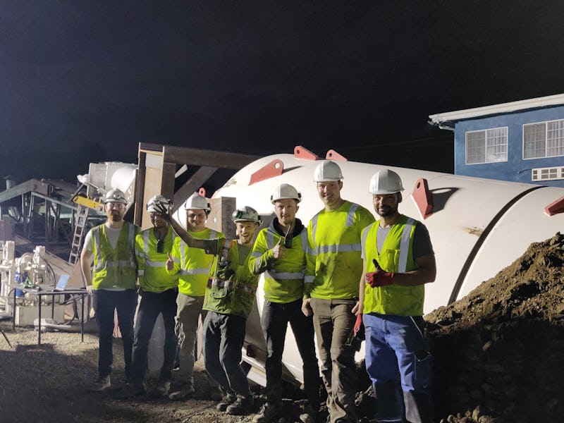 Employees standing in front of The Boring Company’s new machine with smiles on their faces