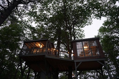 A treehouse that's available on Airbnb in Maine has two rooms and a deck, and is surrounded by trees...