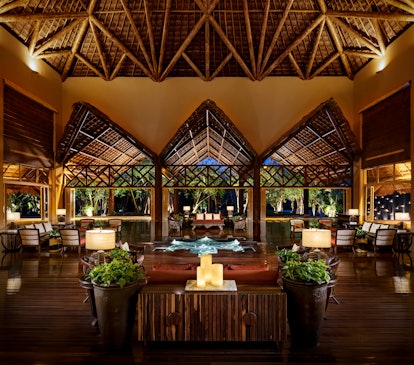 The lobby at Grand Velas Riviera Maya has an outdoorsy design and romantic atmosphere at night.