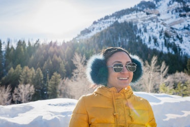 Young woman with earmuffs in snow