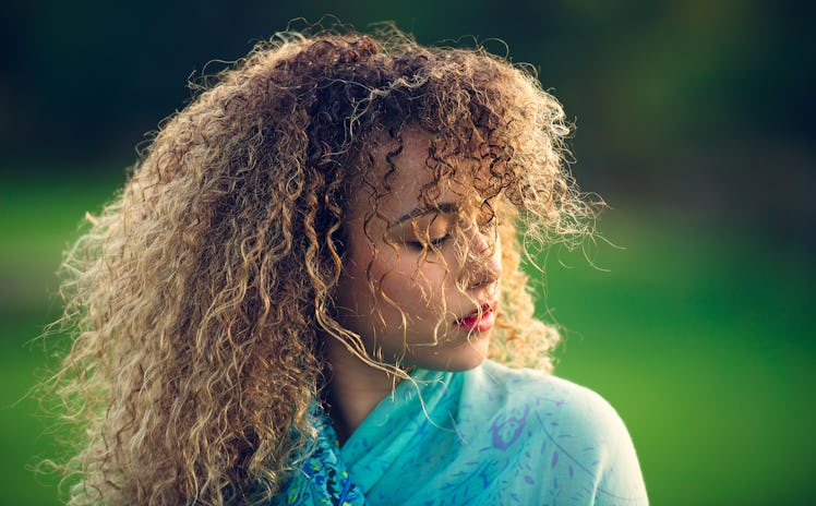Curly-haired young woman outside