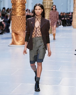 A model in a brown blazer, a leopard print top and cargo shorts walks the runway at chloe's fall 202...