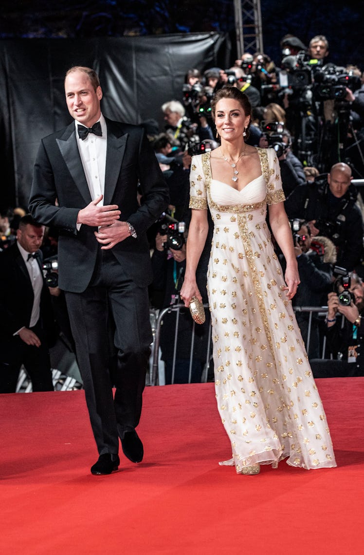 William covering his torso with both his hands walking with Kate, who is fidgeting with her engageme...