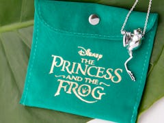 A frog necklace from Disney's 'The Princess and the Frog' jewelry collection by RockLove dangles off...