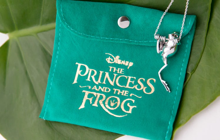 A frog necklace from Disney's 'The Princess and the Frog' jewelry collection by RockLove dangles off...