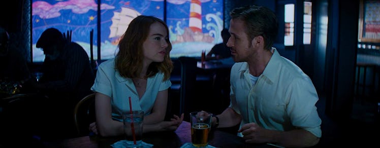 Ryan Gosling and Emma Stone sit in a jazz club during a scene in 'La La Land.'