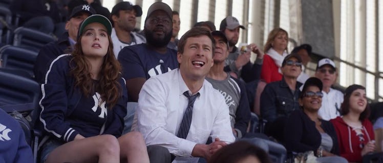 Zoey Deutch and Glen Powell sit in the stands of Yankee Stadium during a scene in 'Set It Up.'