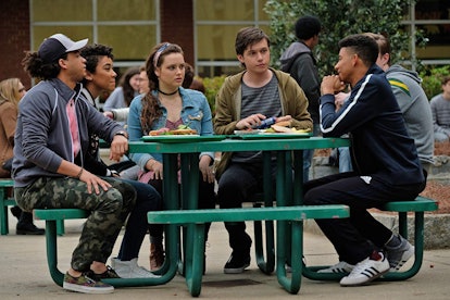 A group of high school friends sits around a table outside their school and talks in 'Love, Simon.'
