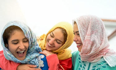 Three women in headscarves smiling